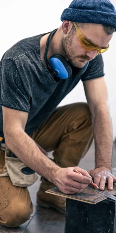 A male worker puts laminate flooring on the floor. A male worker puts laminate flooring on the floor.