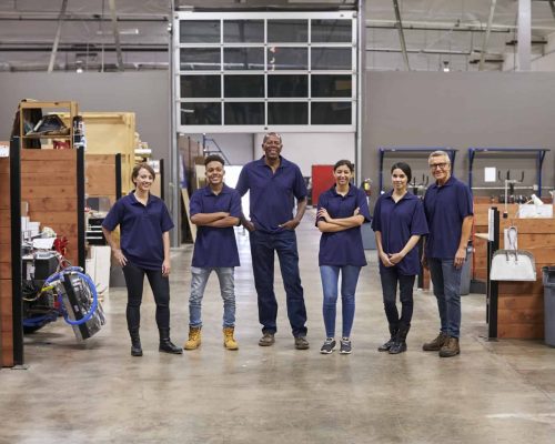 Portrait Of Engineers And Apprentices In Busy Factory Portrait Of Engineers And Apprentices In Busy Factory